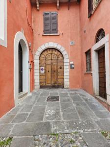 an orange building with a large wooden door at Il Cortiletto- Le Piazze in Brescia