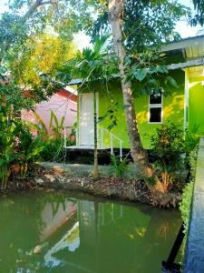 uma casa com um lago em frente em Ban Suan Lung Rin em Kanchanaburi