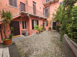 a courtyard of a pink building with potted plants at Il Cortiletto- Le Piazze in Brescia