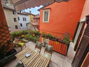 een balkon met een houten tafel, stoelen en bloemen bij Il Cortiletto- Le Piazze in Brescia