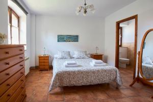 1 dormitorio con cama, tocador y espejo en Rincón de piedra BCN, en Corró de Vall
