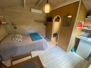 1 dormitorio en una casa pequeña con 1 cama en Le chalet du Jardin caché, en Marmande