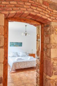 een slaapkamer met een bed in een bakstenen muur bij Rincón de piedra BCN in Corró de Vall
