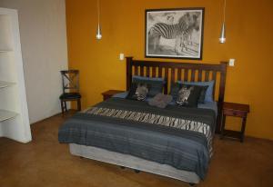 a bedroom with a bed with a zebra picture on the wall at Kiburi Lodge @ Kruger, a secluded Bushveld getaway in Marloth Park +64 photos