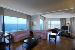 فندق وارويك بالم بيتش في بيروت: غرفة معيشة بها كنبتين وتلفزيون