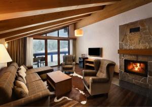 a living room with a couch and a fireplace at Chalets Jasná Collection Centrum in Demanovska Dolina