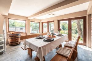 a dining room with a table and a bunch of windows at Holiday home Villa Antique in Bjelovar