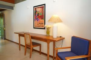 a dining room table with a lamp and a blue chair at Maison Samara in Hikkaduwa