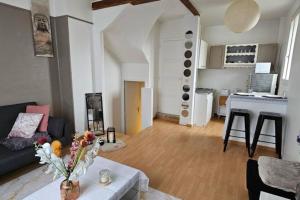 ein Wohnzimmer mit einem Sofa und einem Tisch in der Unterkunft Appartement duplex in Pont-Sainte-Maxence
