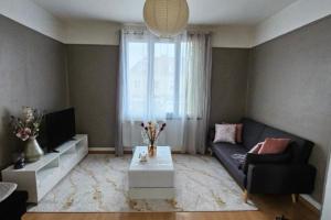 - un salon avec un canapé et une table dans l'établissement Appartement duplex, à Pont-Sainte-Maxence