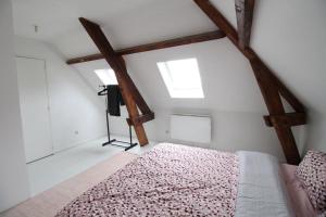 ein Schlafzimmer mit einem Bett im Dachgeschoss in der Unterkunft Appartement duplex in Pont-Sainte-Maxence