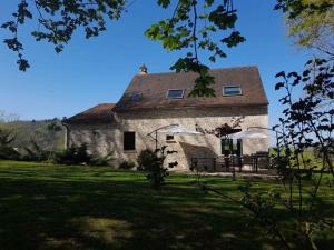 an old stone building with a roof on a field at Villa avec piscine chauffée Périgord Dordogne in Marnac