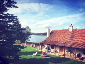 a house with a red roof next to a lake at Lakefront House & Sauna Mazury, quiet beautiful village, domekprzytulny in Ełk