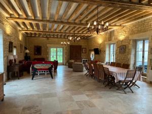 a large living room with a table and chairs at LA CHARMILLE Jolie maison de campagne 14 personnes piscine calme in Entrains-sur-Nohain