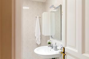a white bathroom with a sink and a mirror at Hotel Da Raffaele in Ischia
