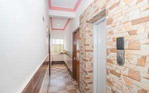 a hallway with a brick wall and a door at Hotel City Plaza in Bangalore