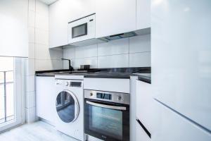 Apartamentos Cuatro Caminos في مدريد: مطبخ أبيض مع غسالة ومجفف