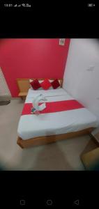 a bedroom with a large bed with red pillows at Hotel City Plaza in Bangalore