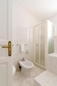 a white bathroom with a toilet and a shower at Hotel Da Raffaele in Ischia