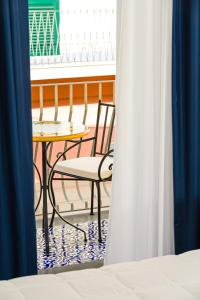 a table and chair on a balcony with a window at Hotel Da Raffaele in Ischia