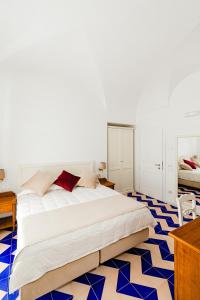 a bedroom with a large white bed with blue tiles at Hotel Da Raffaele in Ischia