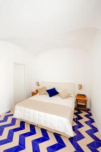 Schlafzimmer mit einem Bett und blauem und weißem Boden in der Unterkunft Hotel Da Raffaele in Ischia