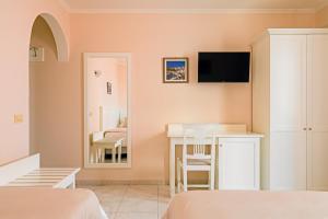 a bedroom with a bed and a table and a mirror at Hotel Da Raffaele in Ischia