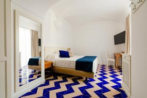 a bedroom with a bed and a blue and white floor at Hotel Da Raffaele in Ischia
