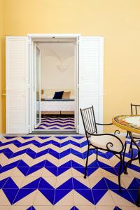 a room with a blue and white floor with a table and chair at Hotel Da Raffaele in Ischia