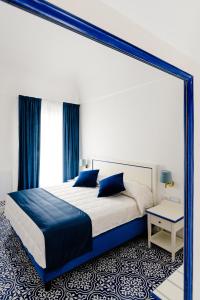 a bedroom with a large bed with a blue frame at Hotel Da Raffaele in Ischia