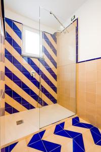 a bathroom with a shower with blue and orange tiles at Hotel Da Raffaele in Ischia
