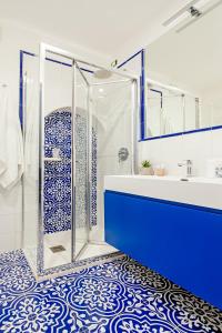 a blue and white bathroom with a shower and a sink at Hotel Da Raffaele in Ischia