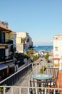 einen Tisch und Stühle auf einem Balkon mit Stadtblick in der Unterkunft Hotel Da Raffaele in Ischia