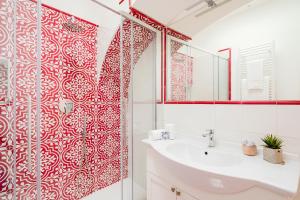 a bathroom with a red and white patterned shower curtain at Hotel Da Raffaele in Ischia