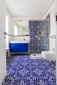 a bathroom with a blue and white tile floor at Hotel Da Raffaele in Ischia