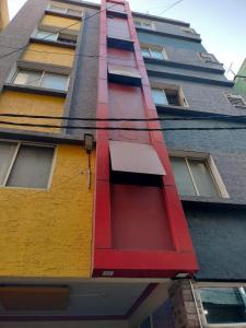 ein mehrfarbiges Gebäude mit einer Leiter auf der Seite in der Unterkunft Hotel City Plaza in Bangalore