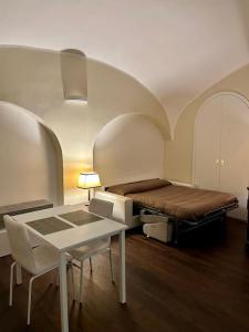 um quarto com uma cama, uma mesa e cadeiras em Maison Petit Bonbon em Turim