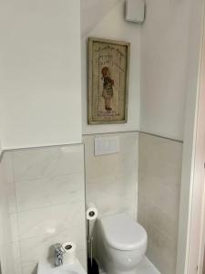 a bathroom with a toilet and a picture on the wall at Maison Petit Bonbon in Turin