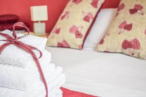 almohada blanca con cinta roja en la cama en Actinia Accommodation, en Alghero