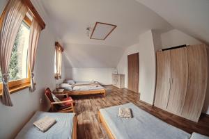 ドルニー・モラヴァにあるChata pod Jasanemのベッド2台と窓が備わる屋根裏部屋です。
