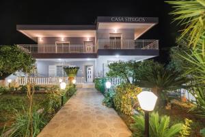 a villa with a walkway in front of a building at Casa Garden in Archangelos