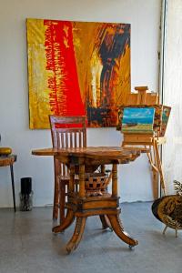 a wooden table and chairs in front of a painting at Nirvana Retreat By Patanjali Wellness Initiative in Ras al Khaimah