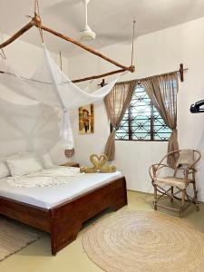 a bedroom with a bed and a chair at Mlango Paje House II in Paje