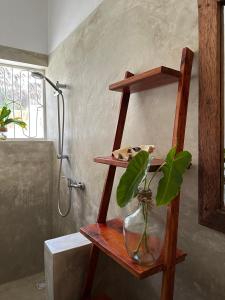 a bathroom with a wooden shelf with a vase with a plant at Mlango Paje House II in Paje