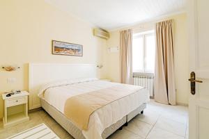 a white bedroom with a bed and a window at Hotel Da Raffaele in Ischia