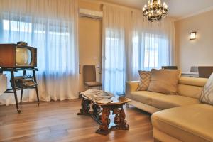 ein Wohnzimmer mit einem Sofa und einem TV in der Unterkunft Alle Porte Del Barocco in Lecce