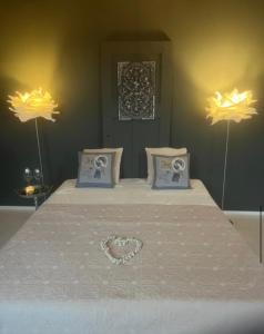 a bed with a heart on it with two lamp w obiekcie de Hoeksesluis w mieście Lekkerkerk