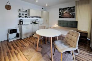 a kitchen and a living room with a table and chairs at Planty Park Apartament in Nowy Sącz +9 photos