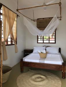 a bedroom with a bed with a basket on it at Mlango Paje House II in Paje