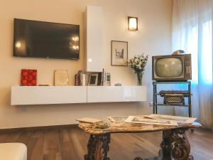 ein Wohnzimmer mit einem TV und einem Couchtisch in der Unterkunft Alle Porte Del Barocco in Lecce